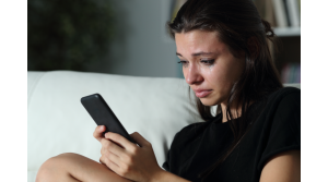 a girl crying looking at her phone